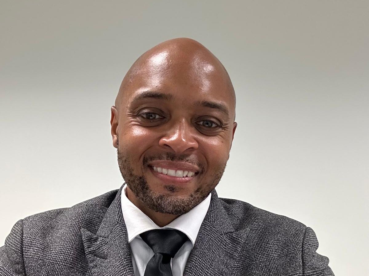 Shawn Watt, Chief Executive Officer of WATT Global, smiling in a grey suit and black tie